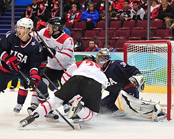 Ryan Miller tries to keep an eye on the puck as players mix it up in front of him. (Getty Images)